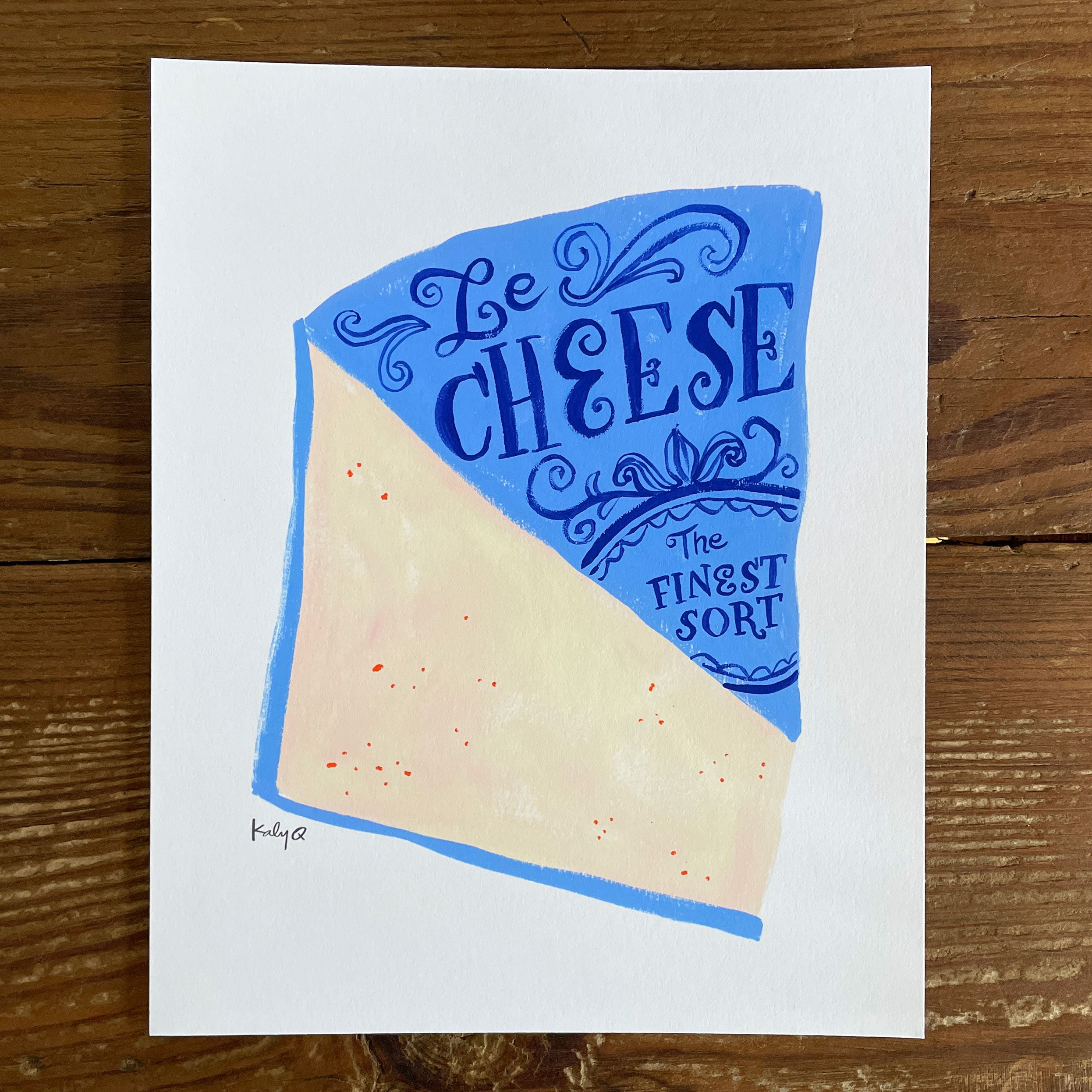 Illustration of a large wedge of creamy pink cheese with bright blue label. Victorian style hand lettering reads Le Cheese: The Finest Sort