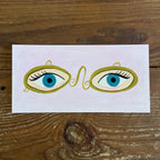Illustration of two flirty eyes in antique optometrist sign on dusty pale pink  background, panoramic format