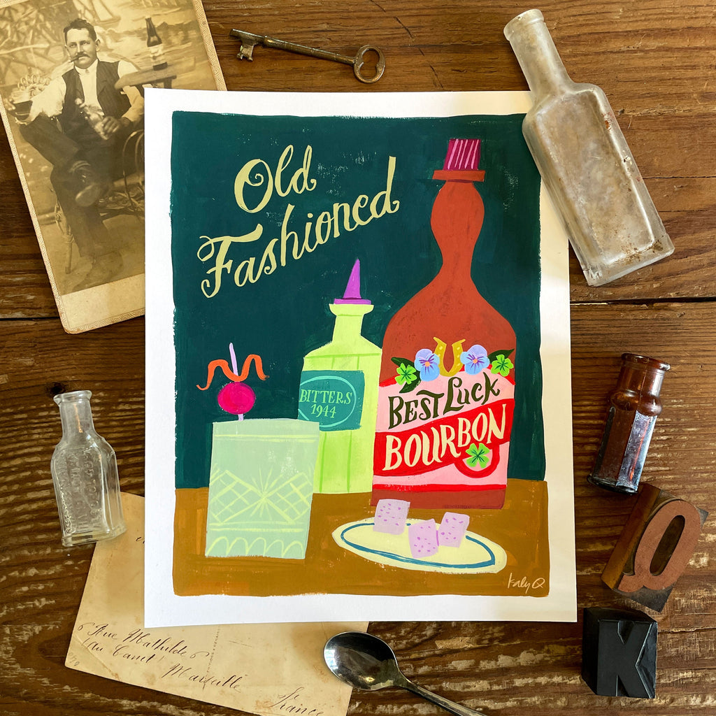 Illustration of an Old Fashioned cocktail with whiskey & bitters bottles and glass with an orange garnish. Hand lettering reads Old Fashioned and Best Luck Bourbon
