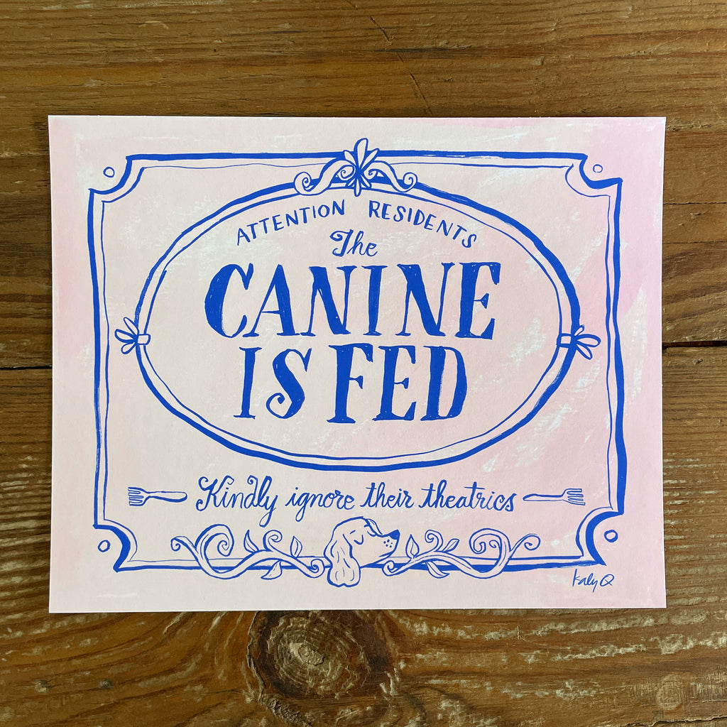 Illustration of a decorative Victorian-style sign on a pale pink background, blue hand lettering reads Attention Residents: The Canine is Fed, Kindly Ignore Their Theatrics