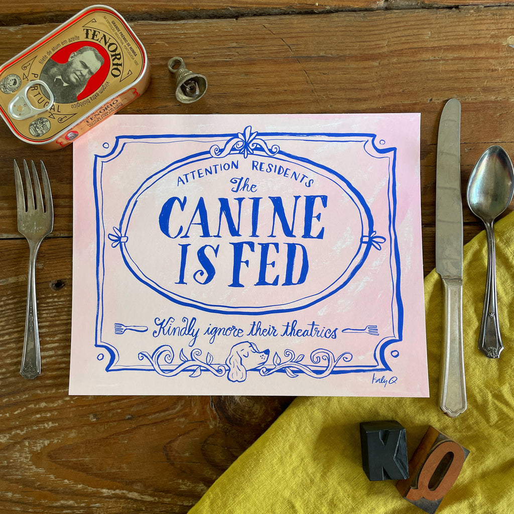 Illustration of a decorative Victorian-style sign on a pale pink background, blue hand lettering reads Attention Residents: The Canine is Fed, Kindly Ignore Their Theatrics