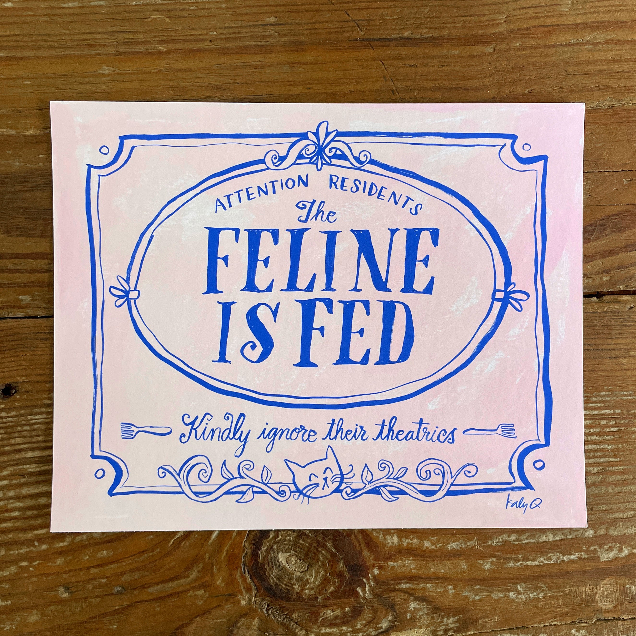 Illustration of a decorative Victorian-style sign on a pale pink background, blue hand lettering reads Attention Residents: The Feline is Fed, Kindly Ignore Their Theatrics