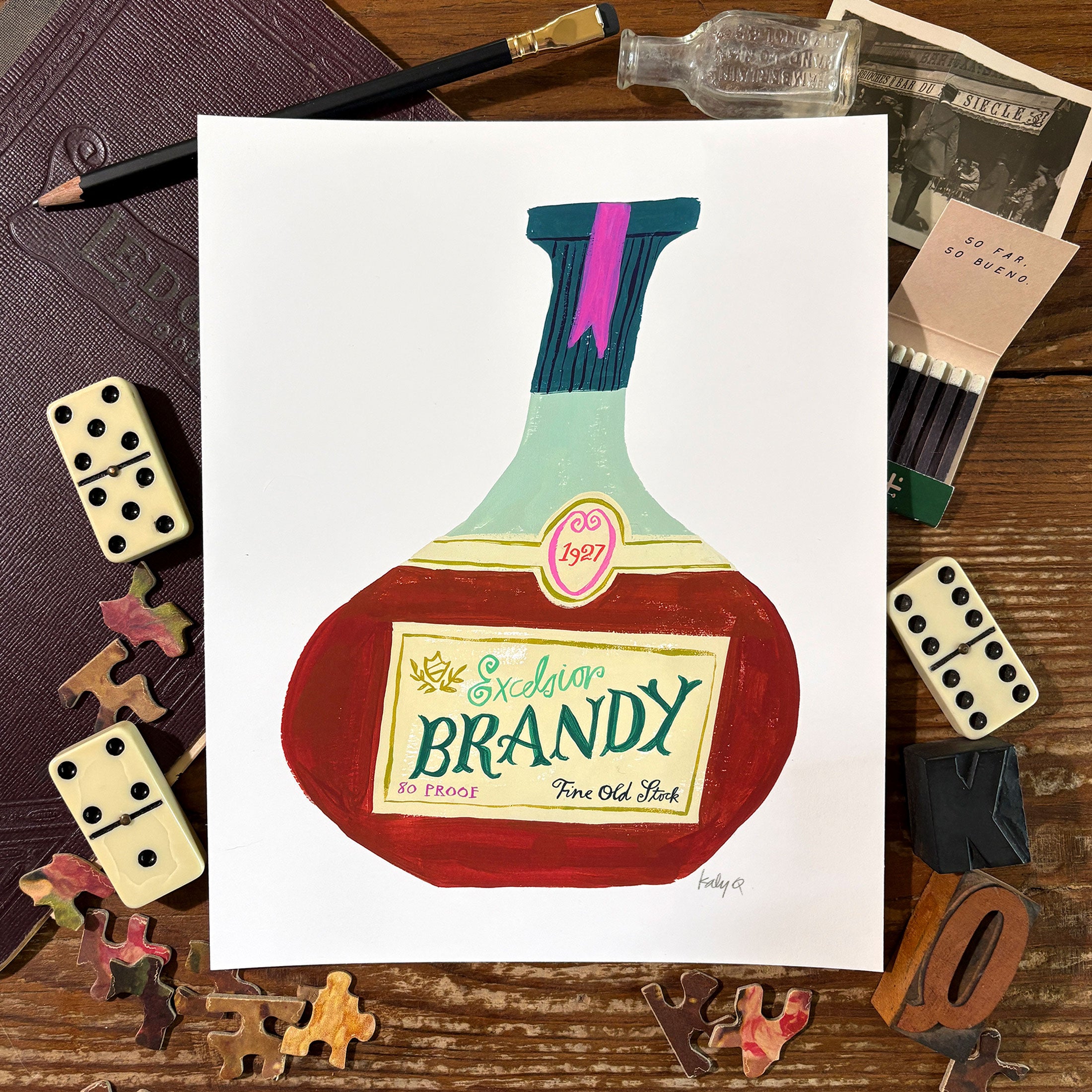 Hand-painted art print of a round vintage brandy bottle with a cream label reading "Excelsior Brandy, Fine Old Stock, 1927" in hand lettered antique style lettering. Styled flat lay on a rustic wooden surface surrounded by dominoes, puzzle pieces, and vintage ephemera.