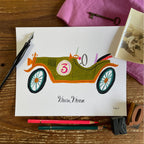 Illustration of an olive green vintage open-top race car with the number 3, hand lettered cursive reads 'Vroom Vroom'